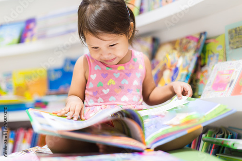 Cuadros en Lienzo Little girl reading a book. Education.