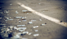 The Shards Of Automotive Glass In The Accident, Lying On The Pavement About Dividing The Solid Lines On The Roadway