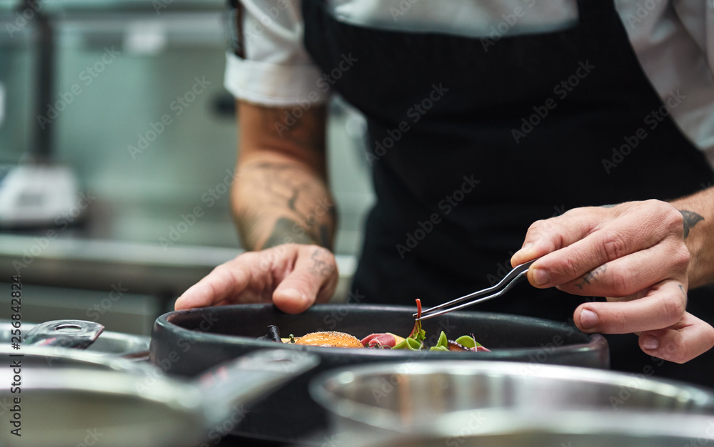 Creative Cooking. Cropped image of chef hands garnishing Pasta carbonara in a restaurant kitchen. - obrazy, fototapety, plakaty 