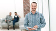© yurolaitsalbert - smiling man with a digital tablet standing in the office.