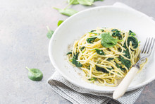 Spaghetti Pasta With Spinach And Green Pesto, In A White Plate On Gray Stone Background