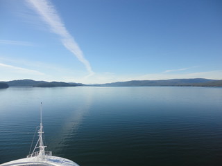 Passage in the Pacific Ocean between two mountain ranges. Calm peaceful waters flowing slowly under a cloudy sky.