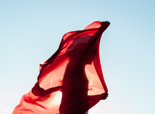 Woman Wrapped In A Red Scarf In The Wind