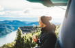 © A_B_C - hipster tourist hold in hands mug of hot drink, lonely smile guy enjoy sun flare mountain in auto, traveler drink cup of tea on nature, vacation weekend concept on background of panoramic landscape