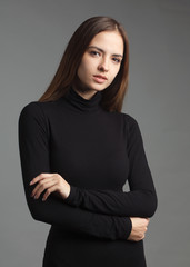 Canvas Print - young caucasian brownhair woman in black turtleneck isolated on gray background