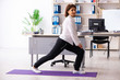 © Elnur - Middle-aged female employee doing exercises in the office