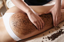 Close Up Of Woman Getting Buttocks And Legs Massage With Coffee Scrub At Spa. Using Coffee Beans For Perfect Skin And Body.