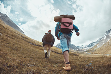 Wall Mural - two hikers goes uphill in mountains