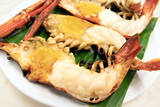 Fototapeta  - Charcoal grilled giant river prawn usually serve with spicy seafood sauce on green banana leaf in restaurant; Thailand's popular dishes. 