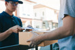 © wutzkoh - Young staff delivery man of the parcel carrier is submitting the documents to the customers to receive at home.