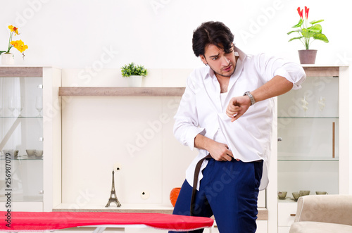 Cuadros en Lienzo Young man ironing in the bedroom