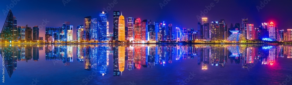 Banner of capital city of Qatar by night. Doha West Bay skyline mirroring in Doha Bay. Panorama of glassed skyscrapers of Doha, Qatar, Middle East, Arabian Peninsula in Persian Gulf. Night urban scene - obrazy, fototapety, plakaty 
