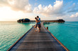 A couple enjoying a sunrise in the Maldives.  