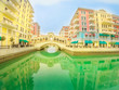 Wide angle view of Venice bridge at Qanat Quartier in the Pearl-Qatar, Persian Gulf, Middle East. Venetian bridge reflecting on canals of picturesque and luxurious district of Doha, Qatar.