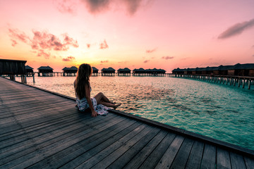 Sticker - A woman enjoying a sunrise in the Maldives