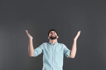 Poster - Portrait of happy young man on grey background. Space for text