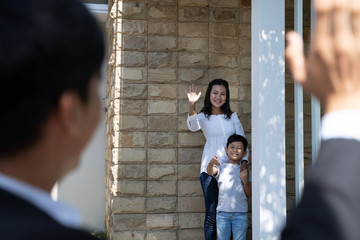 portrait of asian father waving goodbye to his family before going to work