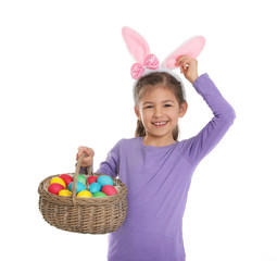 Sticker - Little girl in bunny ears headband holding basket with Easter eggs on white background