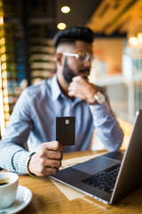 Canvas Print - Smart young Asian man working with laptop and holding credit card for online shopping during drinking coffee in working space.