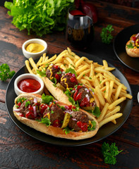 Wall Mural - Meat balls hotdogs with french potato fries, chips, crinkle cut gherkins, ketchup and mustard. fast food