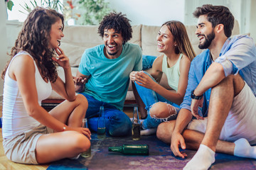 Group of young friends playing game of truth. Home party.