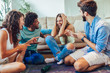 © Mediteraneo - Group of young friends playing game of truth. Home party.