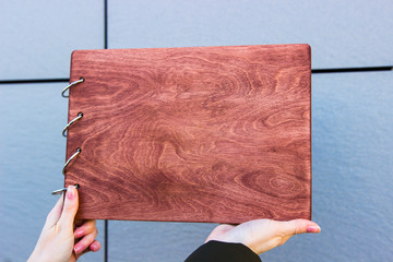 Wall Mural - Vintage wood book in female hands. Book on a desk. old wooden book. Photoalbum album