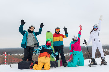 Portrait happy, positive successful snowboarders raising their arms and looking at the camera, young people enjoying time at ski resort. best winter holiday , friendship