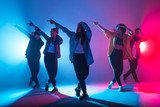 Young modern dancing group of six adult young people practice dancing on colorful background