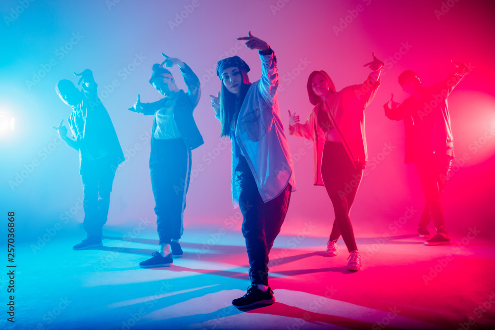 Group of diverse young hip-hop dancers in studio with special lighting ...