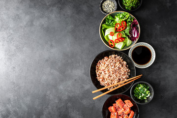 Canvas Print - culinary background of poke bowl ingredients - brown rice, trout or salmon fillet, Chuka Seaweed Salad, sesame and fresh vegetables, top view, copy space, healthy food background