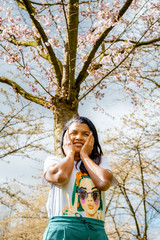 Wall Mural - Woman under blooming cherry blossom tree in Amsterdam cherry blossom tree park