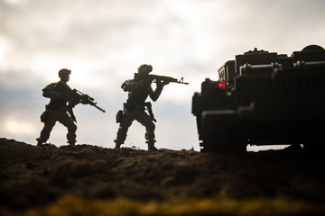 War Concept. Military silhouettes fighting scene on war fog sky background, World War Soldiers Silhouettes Below Cloudy Skyline at sunset. Attack scene. Armored vehicles.