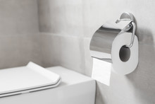Roll Of Toilet Paper Hanging On Metal Toilet-paper Holder At Restroom