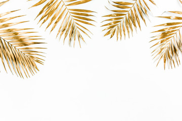 Gold tropical palm leaves on white background. Flat lay, top view minimal concept.