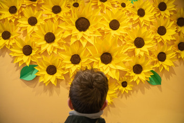 beautiful handmade origami paper sunflowers on the wall. many yellow beautiful flowers.