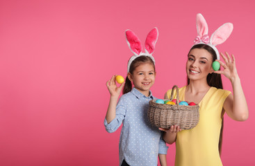 Sticker - Mother and daughter in bunny ears headbands with Easter eggs on color background, space for text