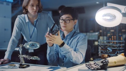 Poster - Technological Prosthetic Robot Arm is Closely Tested by Two Professional Specialists in a High Tech Research Laboratory with Modern Futuristic Equipment. Man and Female Talk and Ananlyse the Object.