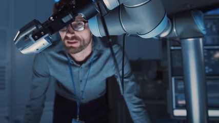 Poster - Close Up of a Futuristic Robotic Arm Moving a Metal Object and Placing It. Team of Engineers Discuss This Advanced Process. They are in a High Tech Research Laboratory with Modern Equipment.