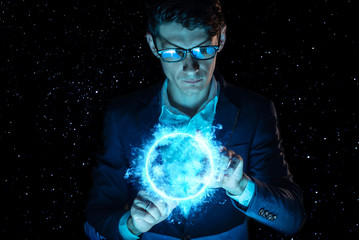 Man businessman holding hands over a blue glowing plasma sphere. Magic prediction and foresight in business and Finance