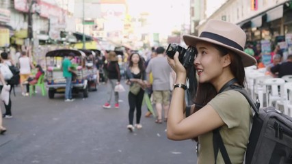 Wall Mural - Asian traveler/tourist walking and travelling taking photo in Khao San rd. walk street, Bangkok, Thailand