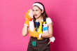 © sementsova321 - Funny charming young Caucasian housewife wearing casual t shirt and apron, orange rubber gloves, holding sponges at her face, imagines that is phone, has fun while doing chores. Hygiene concept.