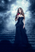 Fantasy Woman In Black Dress Smelling Rose Flower, Mystic Girl In Long Retro Gothic Gown