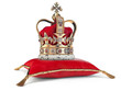 Golden crown on red velvet pillow for coronation. Royal symbol of british UK monarchy.