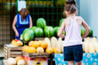 © Kiryakova Anna - Teenager girl on a scooter stands near the counter with watermelons and melons