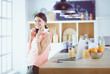 © lenets_tan - Young woman in kitchen with laptop computer looking recipes, smiling. Food blogger concept.