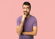 © luismolinero - Handsome man having doubts while looking up on isolated pink background