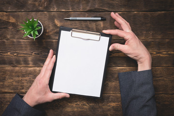 Wall Mural - Signing of business contract or agreement mock up. To do list with copy space. Blank paper page in a businessman hands on office table background.