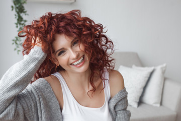 Very attractive young woman close up portrait. Beautiful female indoor. Curly haired lady. Red-haired girl. Redhead with wavy hair.