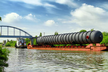 Heavy Oversized Chemical Apparatus Is Transported By River Transport Through The Shipping Channel On A Special Barge